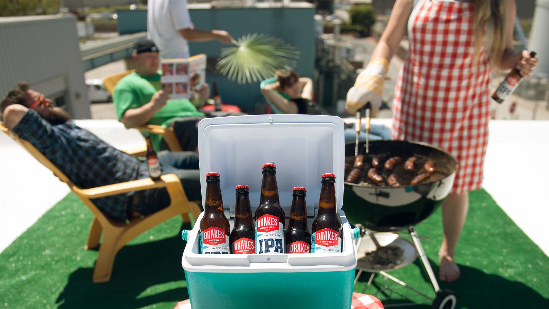 A cooler filled with Drake's IPA and staff in enjoying a cook out