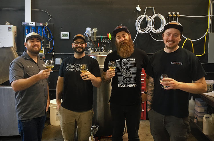 Brewery team with beards and beer glasses in a brewery