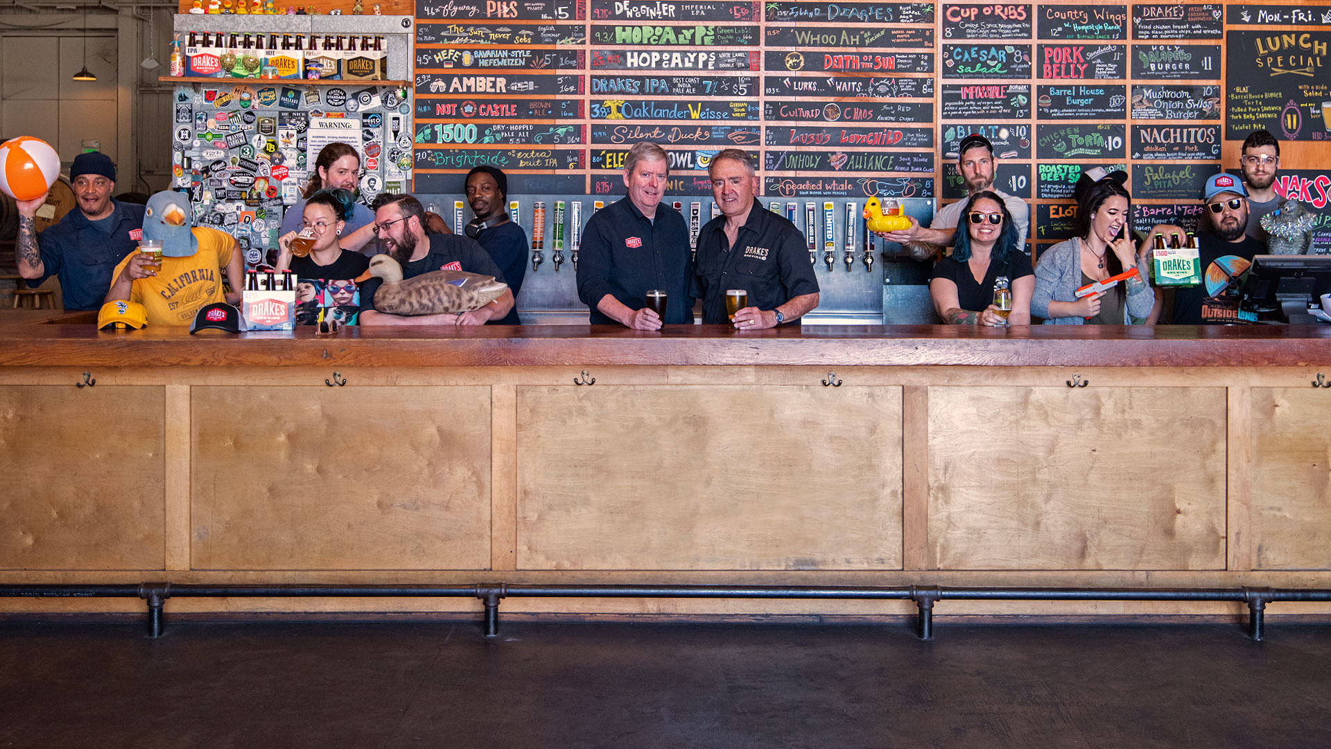 Drake's ownership surrounded by staff behind the Barrel House Bar