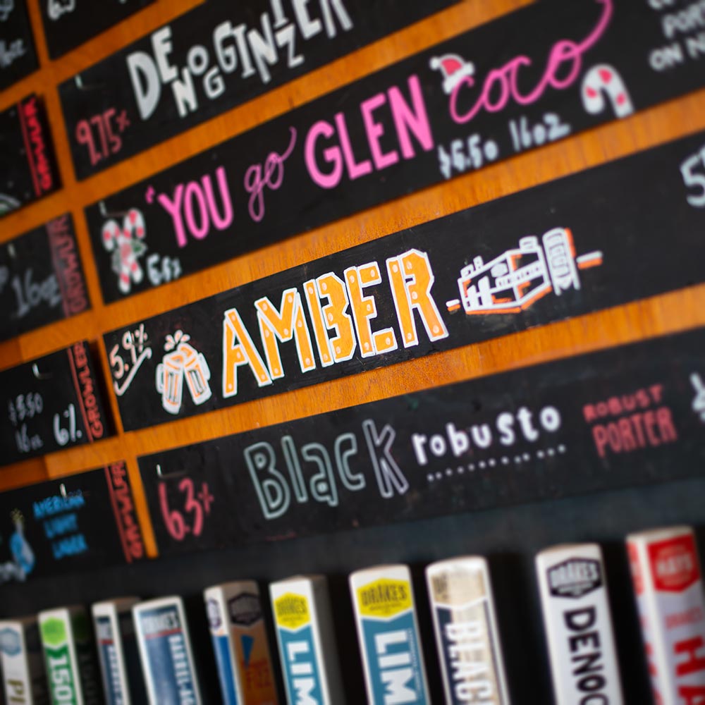 Beer tap list chalkboard with names like Amber, Black, and Glen Coco