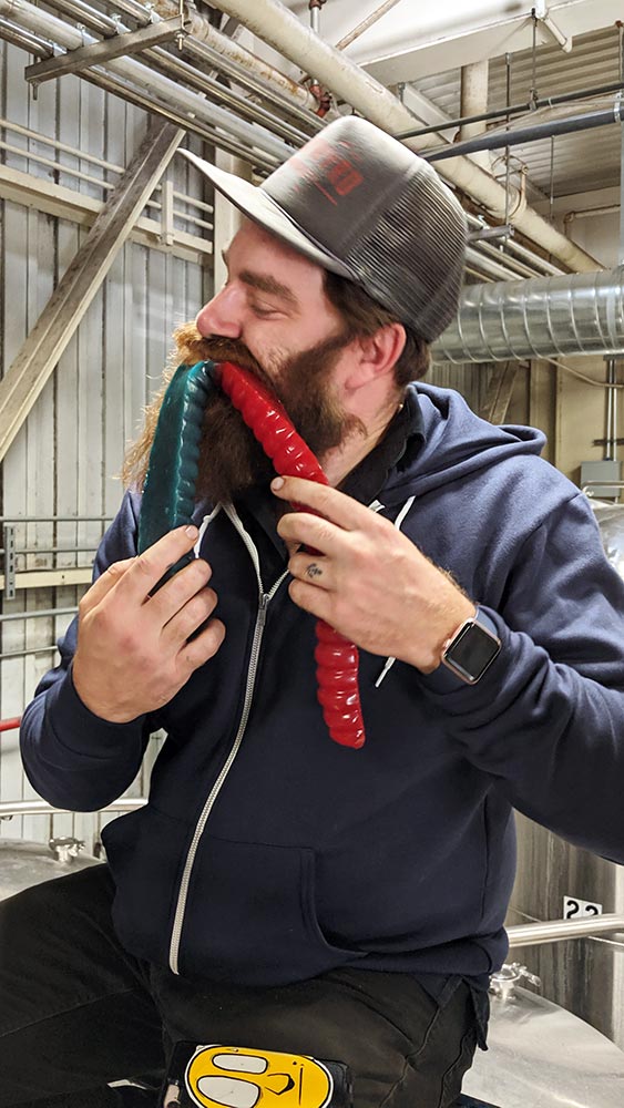 Man with beard and hat plays with red and green novelty items