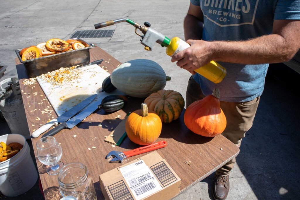 man holding a torch ready to roast a pumpkin