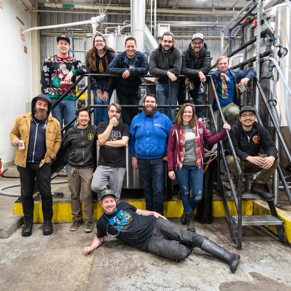 Barebottle Brewing and Drake's Brewing STaff posing together neat the brewhouse