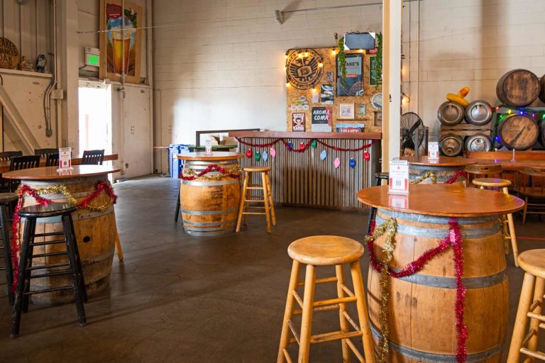 A view of the side bar with beer barrel tables and bar seats clustered in a group