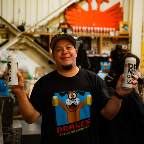 Drake's Brewing Company employee holds cans of Ember and Denver Ginger