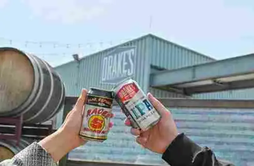 Two cans of Drake's beer are clinked in a toast outside the brewery