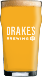Drake's Brewing Co. pint glass filled with golden beer and foam