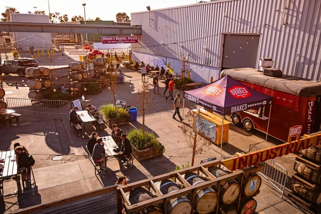 Barrel-aged beer tasting event at an industrial brewery with food trucks